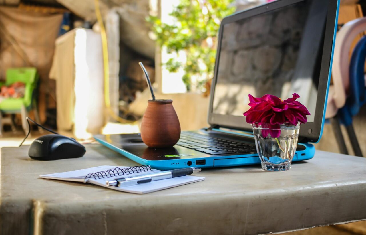 white notebook beside blue laptop computer - Digital Nomad